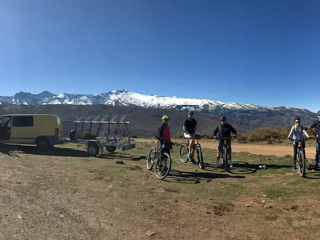 Un groupe de vététistes posant avec leurs vélos et une camionnette d'assistance